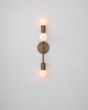 Wall-mounted light fixture with three visible bulbs on a plain background
