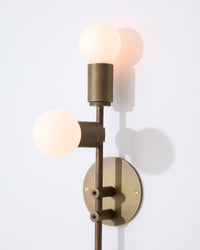 Modern wall-mounted light fixture with three bulbs on a white background