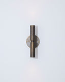 Wall-mounted light fixture with a metallic finish on a light gray background