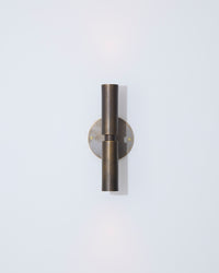 Wall-mounted light fixture with a metallic finish on a light gray background