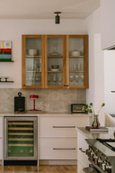 Modern kitchen with wooden cabinets, wine cooler, and decorative items.