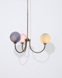 Modern chandelier with three colorful glass bulbs on a white background