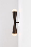 Modern wall-mounted light fixture with two bulbs on a plain background