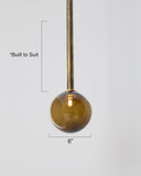 Decorative pendant light with a gold fixture and brown glass shade on a white background.